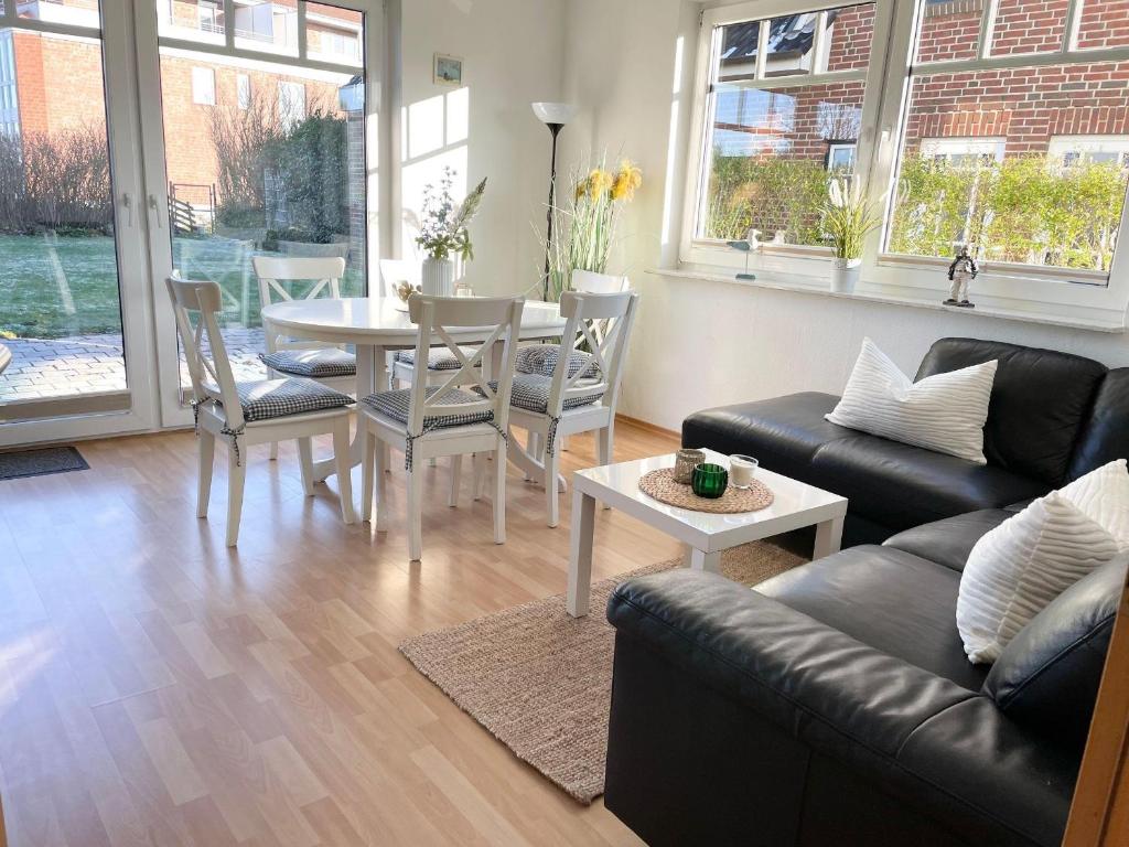 een woonkamer met een bank en een tafel en stoelen bij Ferienhaus-Haus-Eversand in Cuxhaven