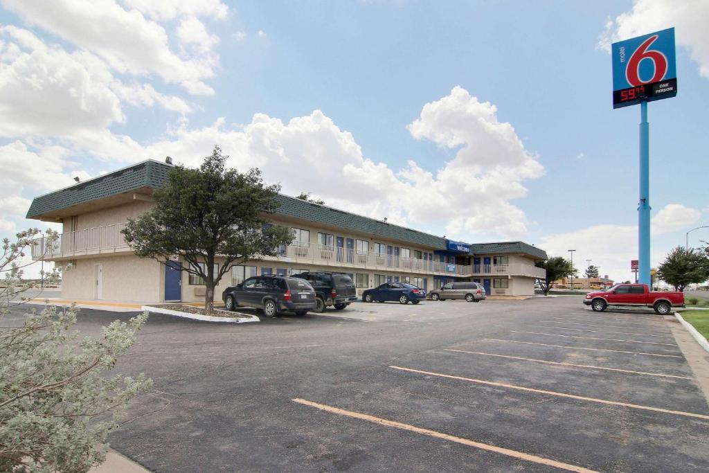 un hotel con coches estacionados en un estacionamiento en Motel 6-Fort Stockton, TX, en Fort Stockton
