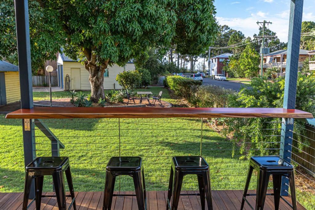 a porch with three stools and a swing at Torquay Treasure in Torquay