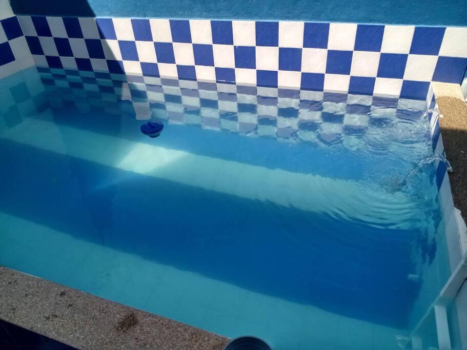 a pool filled with water with a checkeredkered at casa turística Mónaco 48 in Carmen de Apicalá