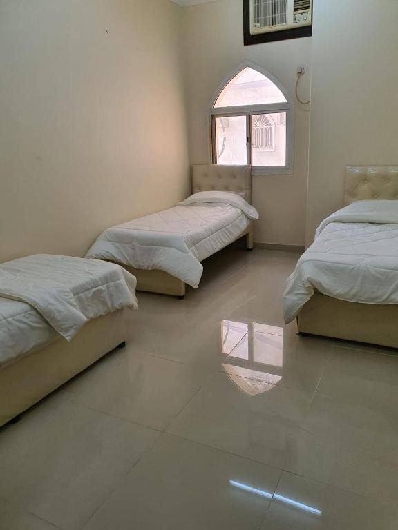 Burj Al Haram 2 Al Masarat في مكة المكرمة: سريرين في غرفة مع انعكاس في الأرضية