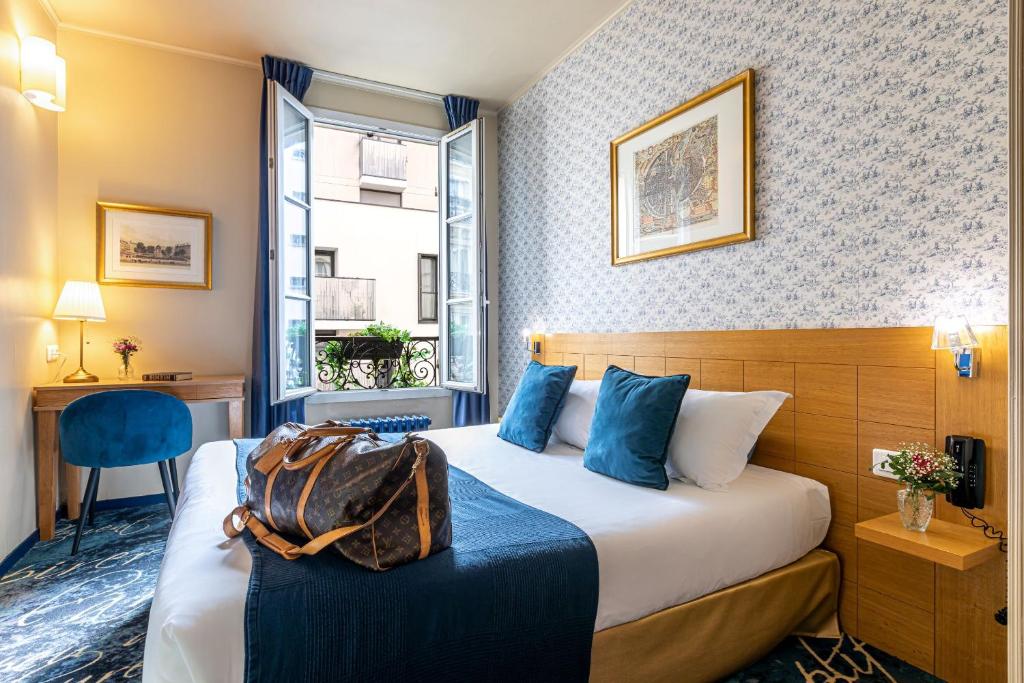 ein Hotelzimmer mit einem Bett, auf dem eine Tasche liegt in der Unterkunft Hotel Romance Malesherbes by Patrick Hayat in Paris