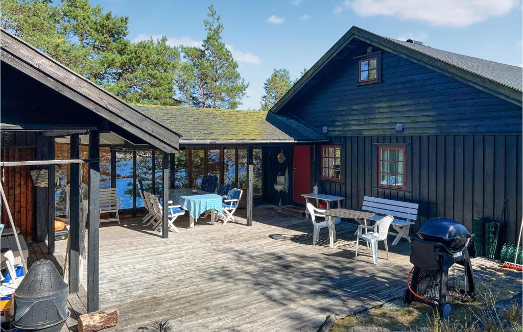 a house with a deck with a grill and a table and chairs at Amazing Home In Krager With 4 Bedrooms in Kragerø
