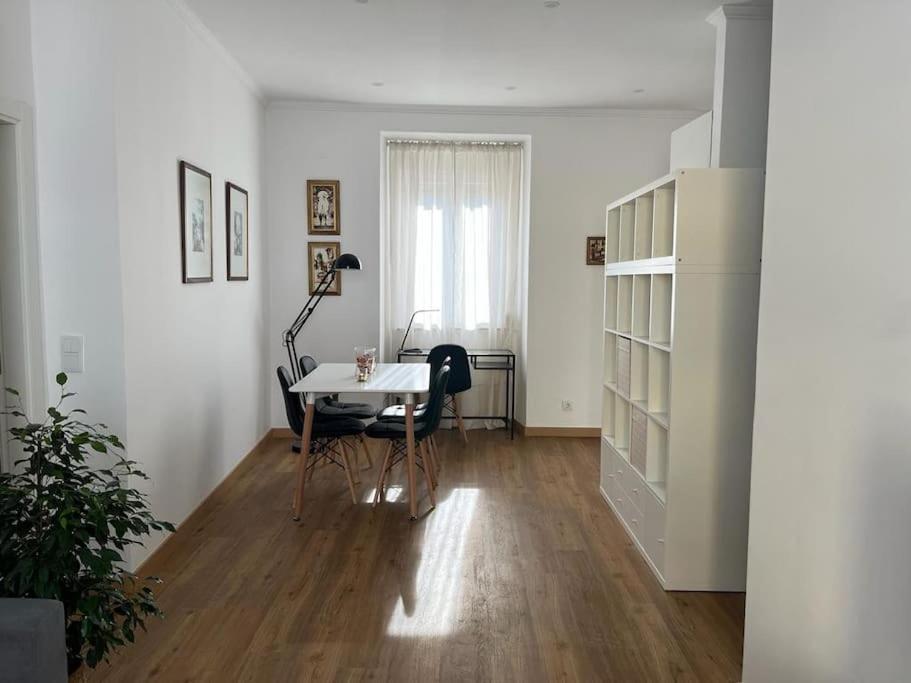 ein Wohnzimmer mit einem Tisch und einem Schreibtisch in der Unterkunft CASA DA PRAIA DA POÇA - APARTAMENTO LÍRIO in Estoril