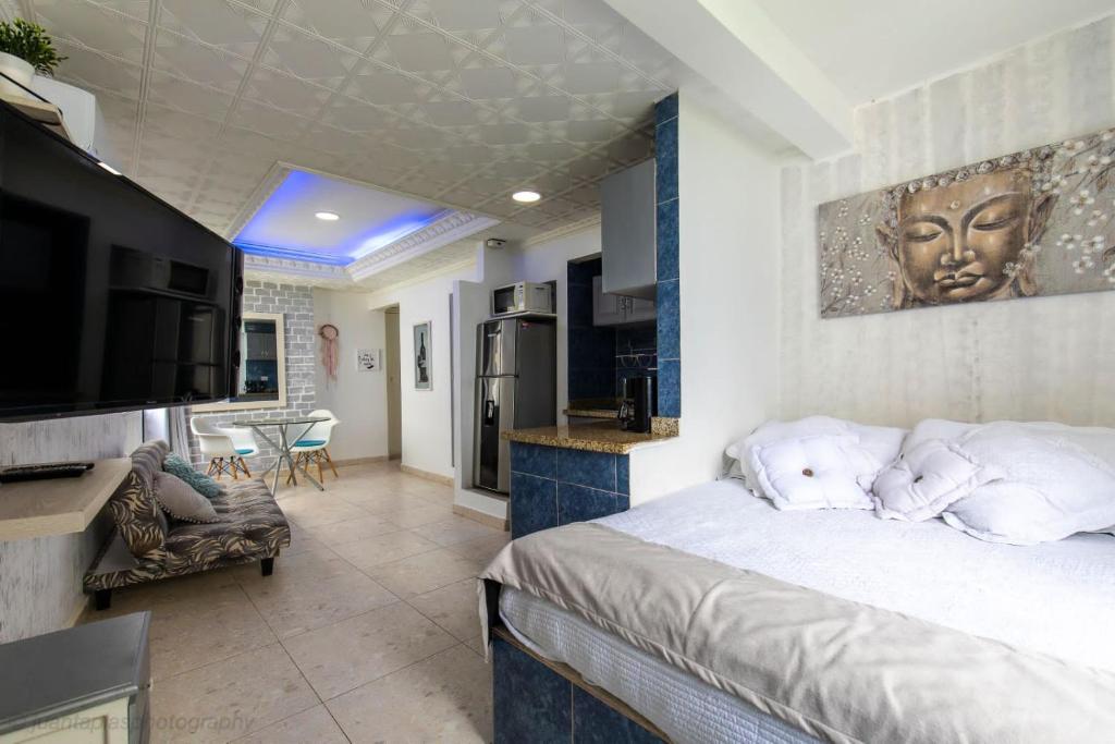 a bedroom with a large bed and a kitchen at APARTASUITES CON VISTA AL MAR in Cartagena de Indias