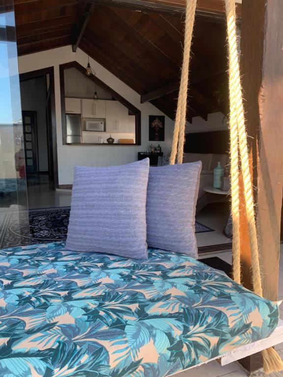 1 cama con 2 almohadas moradas en el porche en Cobertura Dos Amores Na melhor localização da Praia Brava- Balneário Camboriú, en Balneário Camboriú