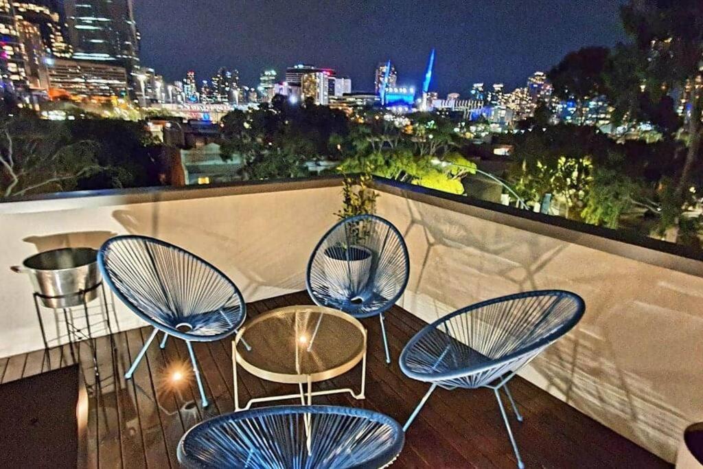 three chairs and a table on a balcony at night at Flagstaff Hill West Melbourne in Melbourne