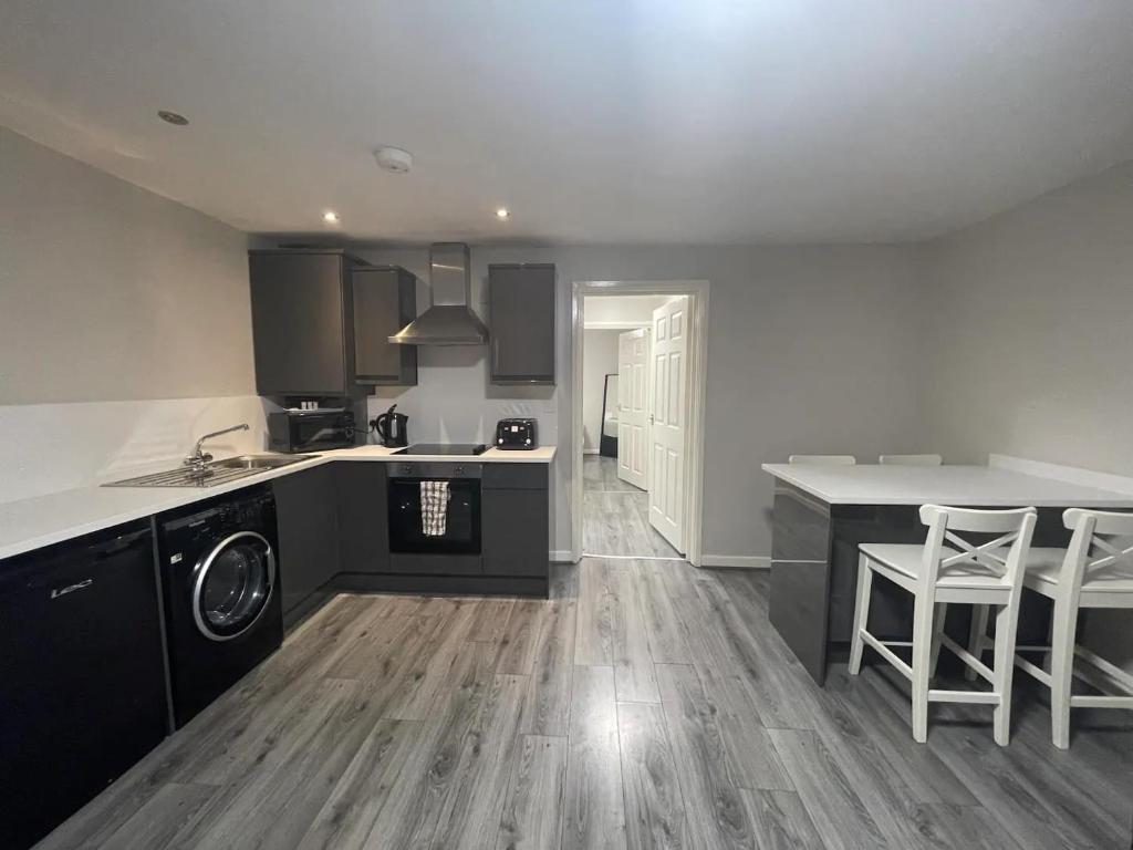 a kitchen with black and white appliances and wooden floors at Hosted By Ryan - 2 Bedroom Apartment in Liverpool