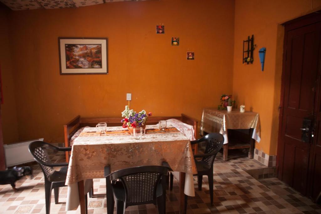 comedor con mesa, sillas y paredes de color naranja en Departamento Inti Raymi en Tilcara