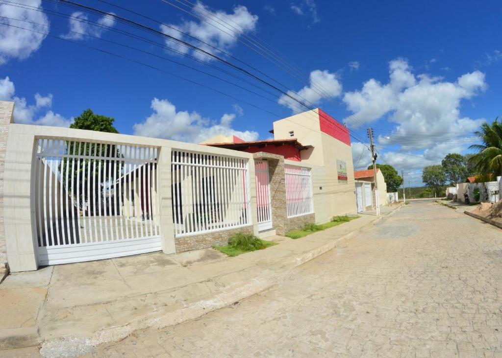 une clôture blanche sur le côté d'une rue dans l'établissement Pousada Marihá, à Piranhas