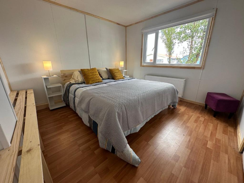 Un dormitorio con una cama grande y una ventana en Patagonia Sweet Home, en Puerto Natales