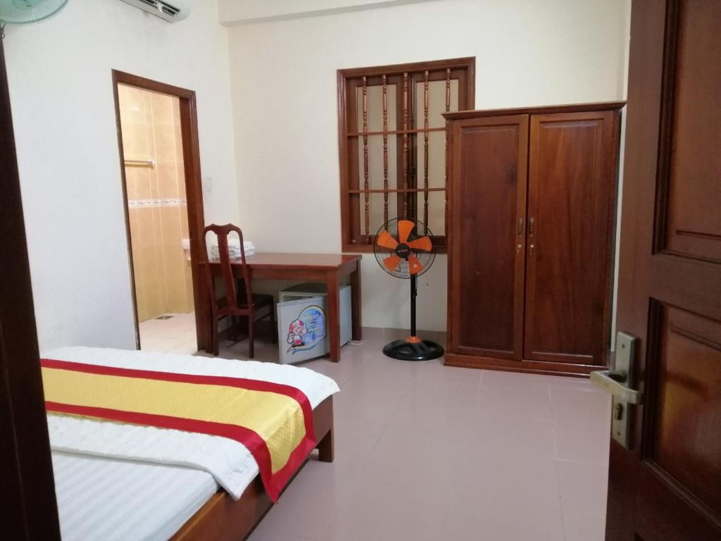 a room with two beds and a cabinet and a desk at Motel Toàn Thắng 2 in Vung Tau