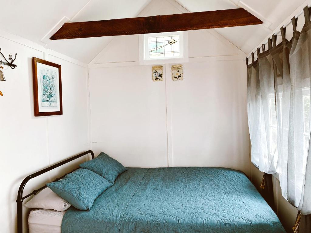 um pequeno quarto com uma cama num quarto em Thistle and Pine Cottage Farmstay em Tauranga