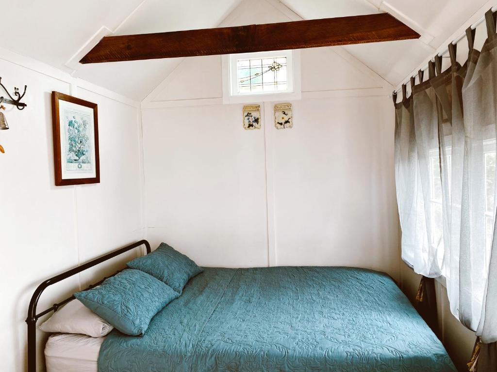 a small bedroom with a bed in a room at The little cottage in Tauranga
