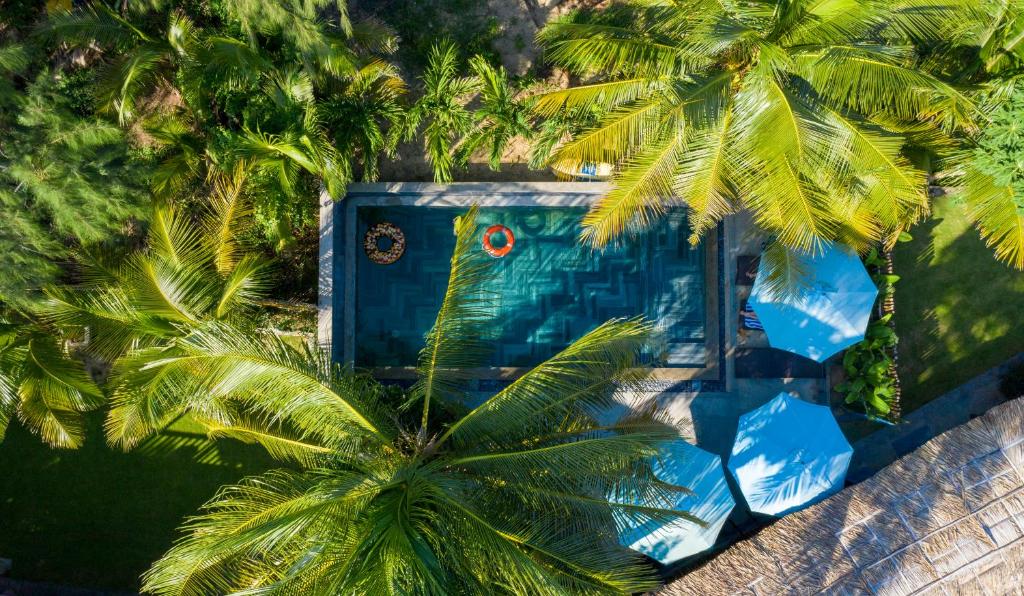 een uitzicht over een zwembad met palmbomen bij Salt Villa 3BR Oceanview An Bang Beach Hoi An in An Bàn (2)