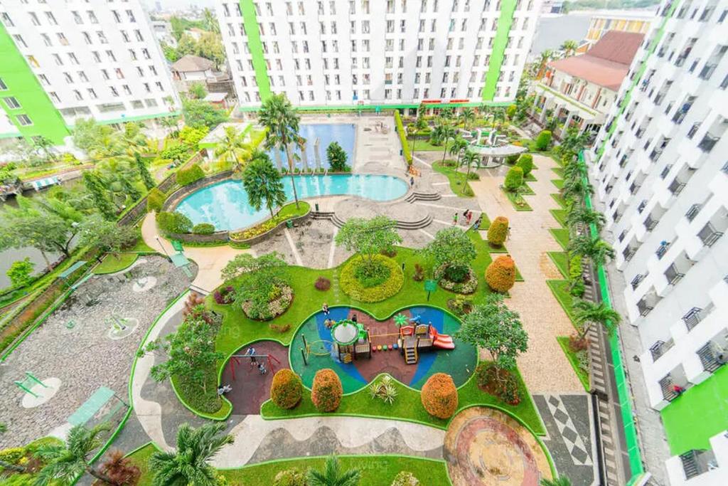 einen Blick über einen Park mit Pool in der Unterkunft RedLiving Apartemen Green Lake View Ciputat - Pelangi Rooms 3 Tower E in Tangerang