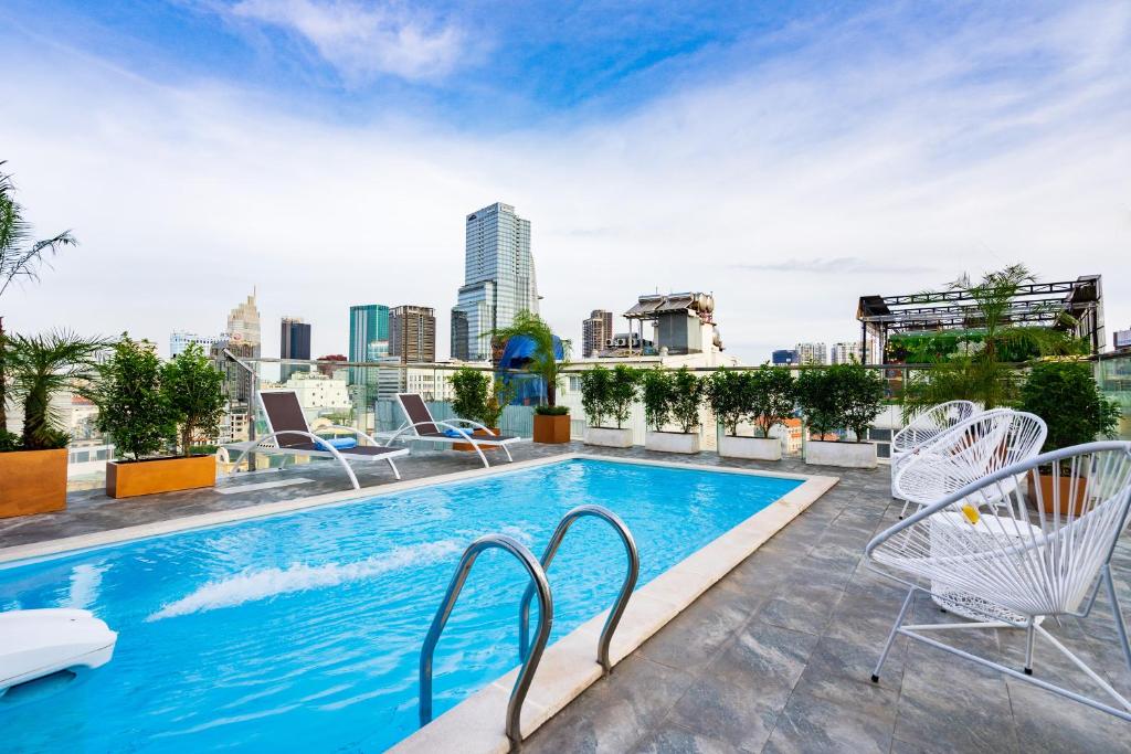 einem Pool auf einem Gebäude mit Skyline der Stadt in der Unterkunft Jovia Hotel in Ho-Chi-Minh-Stadt