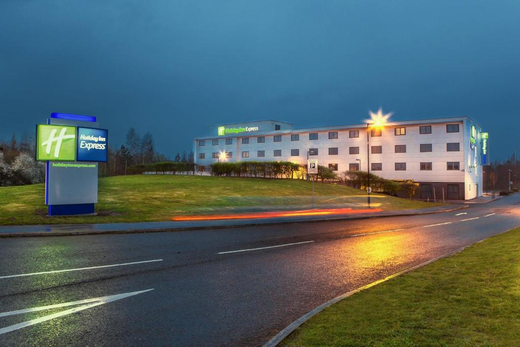 uma rua vazia com um edifício ao fundo em Holiday Inn Express Manchester Airport, an IHG Hotel em Hale