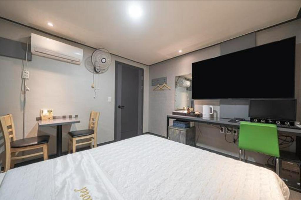 a bedroom with a bed and a flat screen tv at Alps Motel in Incheon