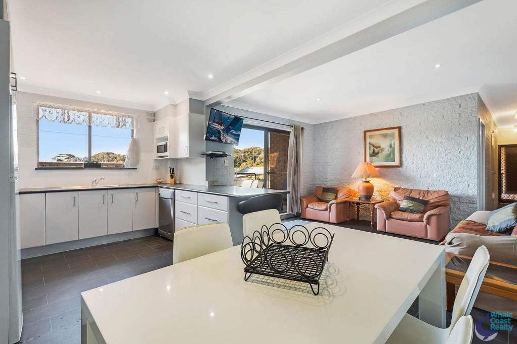 a kitchen and living room with a table and chairs at Apollo Unit 15 1st Floor in Narooma