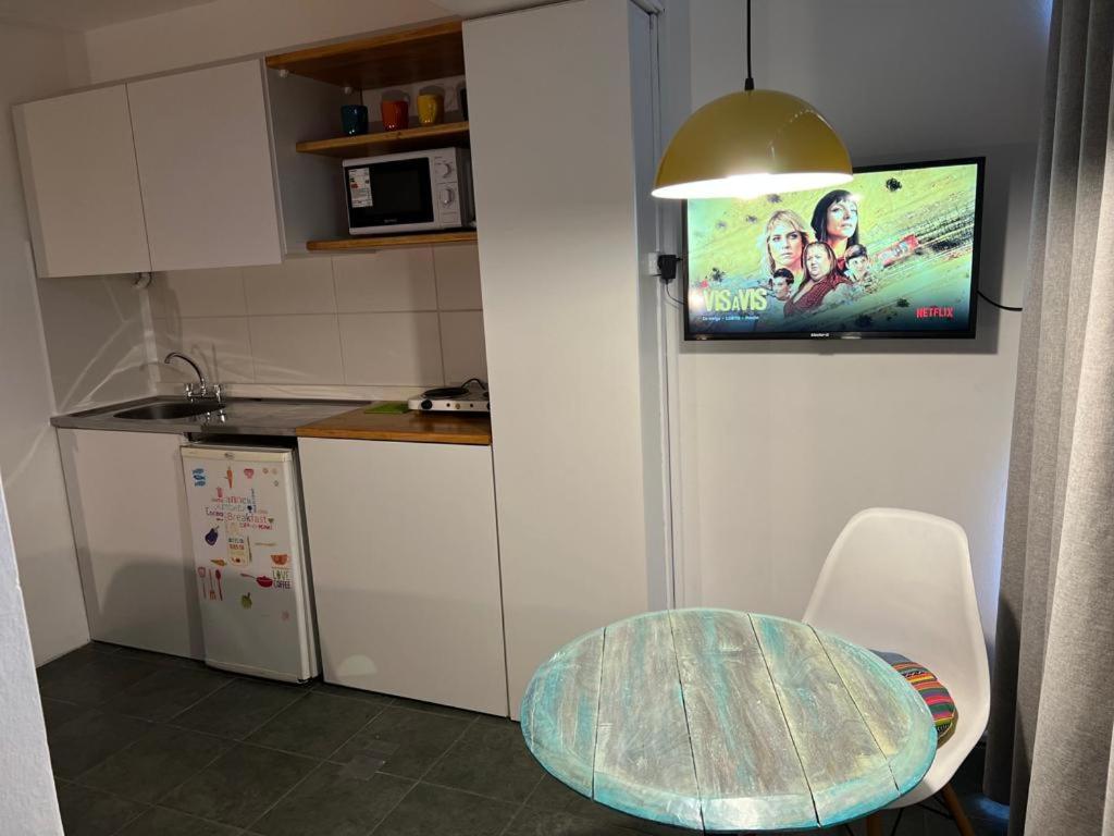 una pequeña cocina con mesa y TV en la pared en Monoambiente céntrico en Mendoza en Mendoza