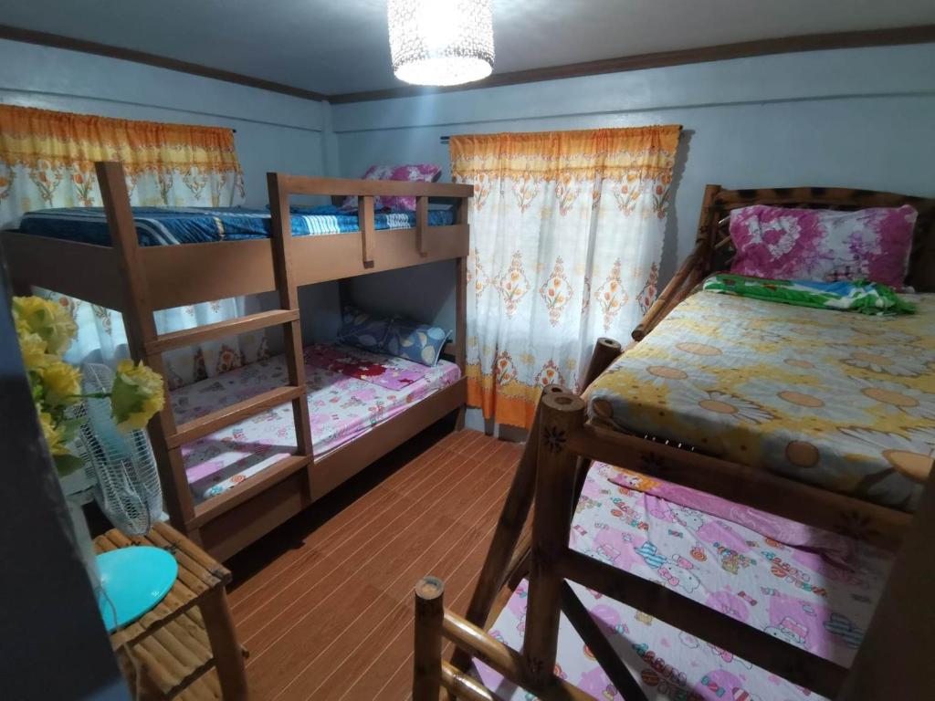 a bedroom with two bunk beds and a staircase at Zeah's Beach Place in Bulusan