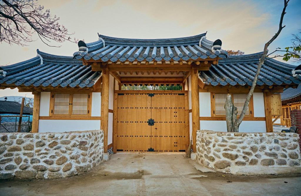 a gate to a building with a roof at Hanok Stay - JukRokJungSa in Gurye