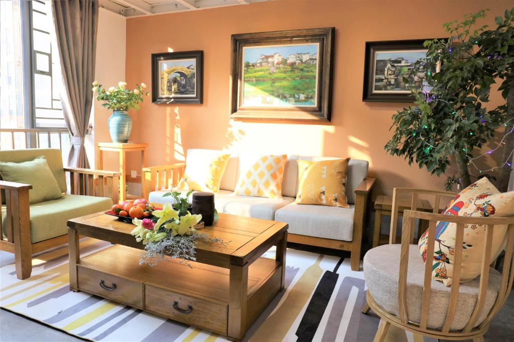 - un salon avec un canapé et une table dans l'établissement Guangzhou He She Art Apartment, à Canton