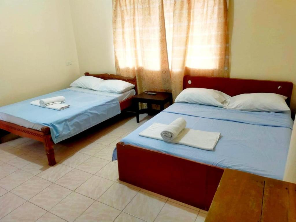 OYO 931 Moreno's Lodging Boracay في بوراكاي: سريرين في غرفة عليها مناشف