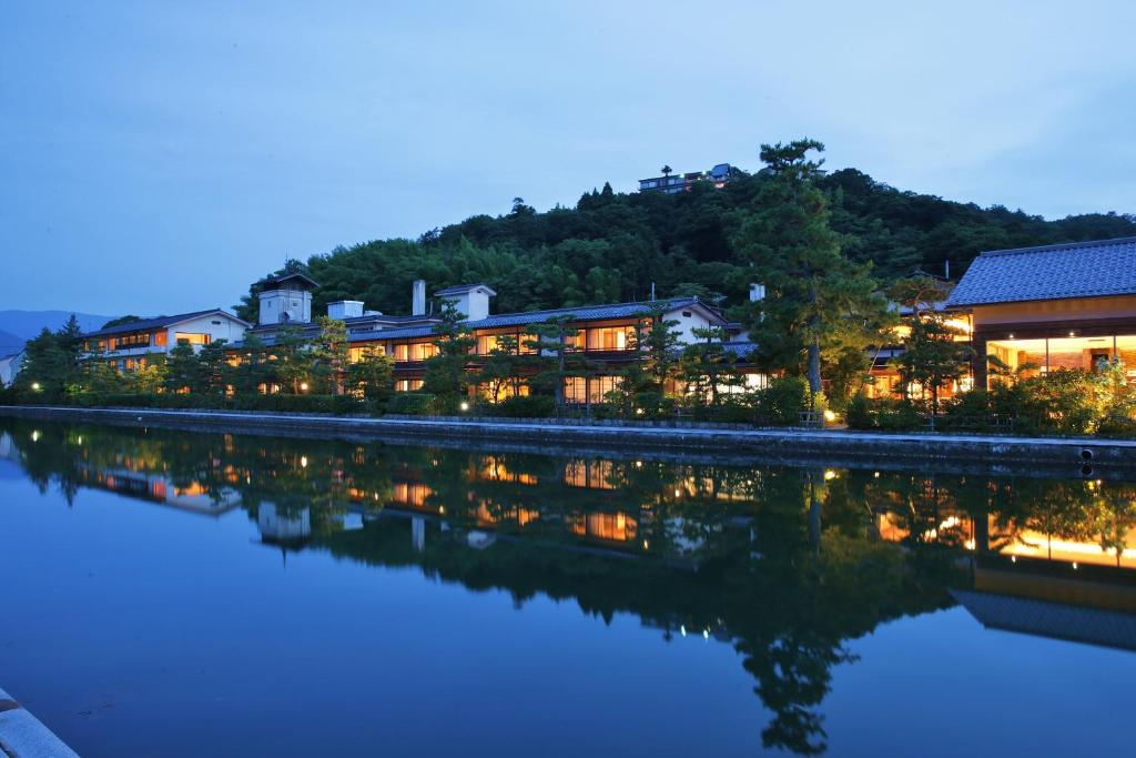 a resort with lights on the water at night at Monjusou in Miyazu