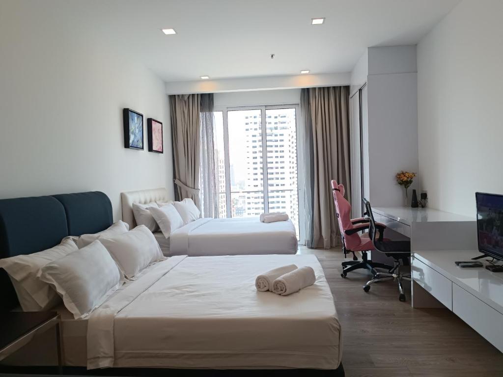 ein Hotelzimmer mit 2 Betten und einem Schreibtisch in der Unterkunft RM020 Bukit Bintang 118 Tower Balcony View in Kuala Lumpur