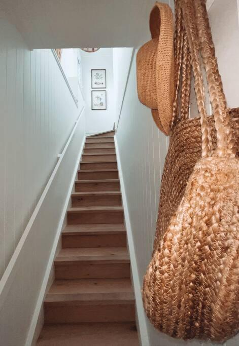a hallway with a staircase with a large purse at HighTide- luxury apartment, almost on the beach. in Corlette
