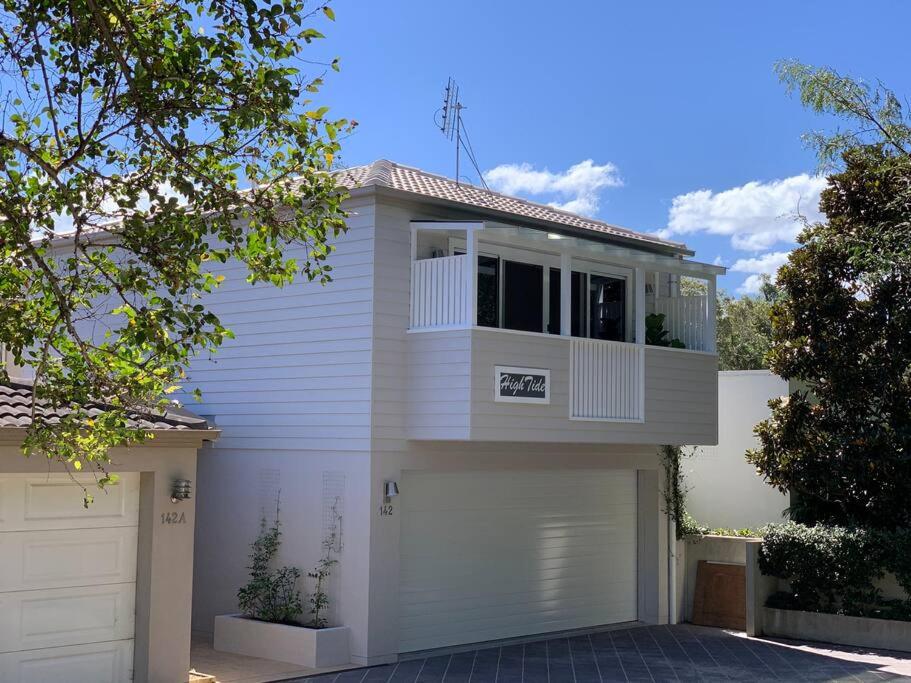 a white house with a white garage at HighTide- luxury apartment, almost on the beach. in Corlette