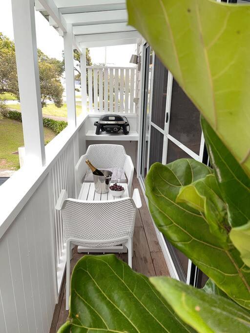 a porch with a table and chairs and a grill at HighTide- luxury apartment, almost on the beach. in Corlette