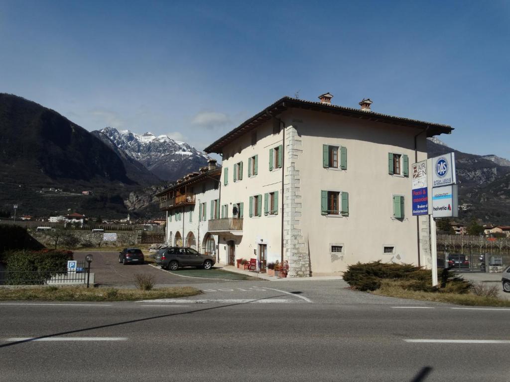 ein großes weißes Gebäude an der Straßenseite in der Unterkunft GARDAINN La CASCINA in Riva del Garda