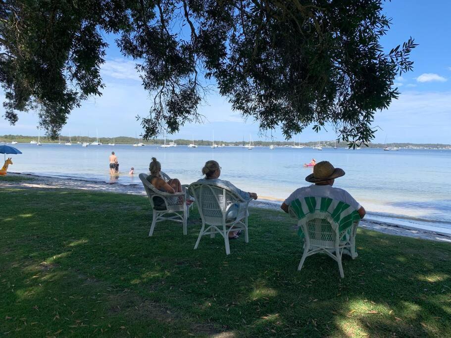 a group of people sitting in chairs on the beach at HighTide- luxury apartment, almost on the beach. in Corlette