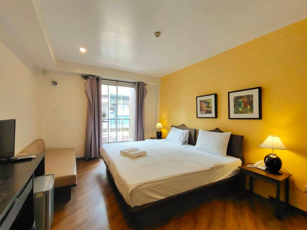 a bedroom with a large bed and a television at Vinary Hotel Sukhumvit - SHA EXTRA Plus in Bangkok