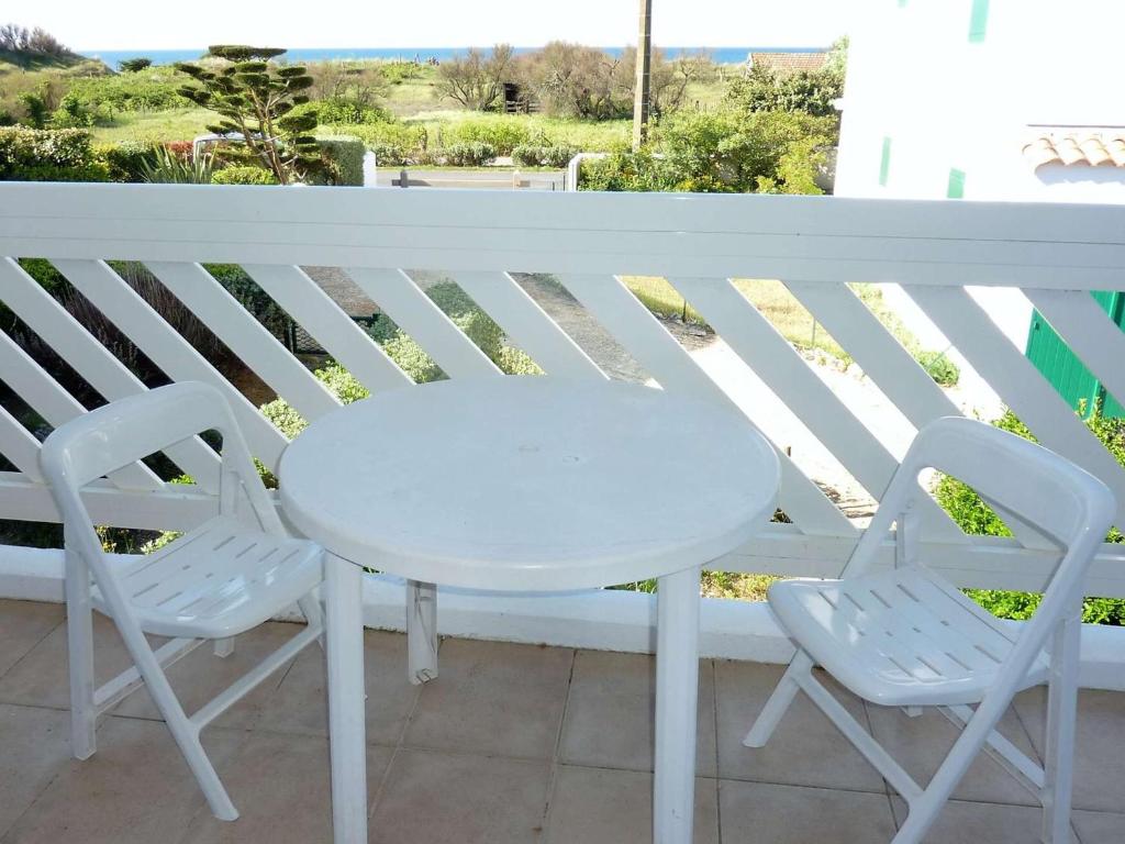 d'une table blanche et de deux chaises sur un balcon. dans l'établissement Appartement 5 pers, près plage, balcon, parking, La Cotinière - FR-1-246A-89, à Saint-Pierre-dʼOléron