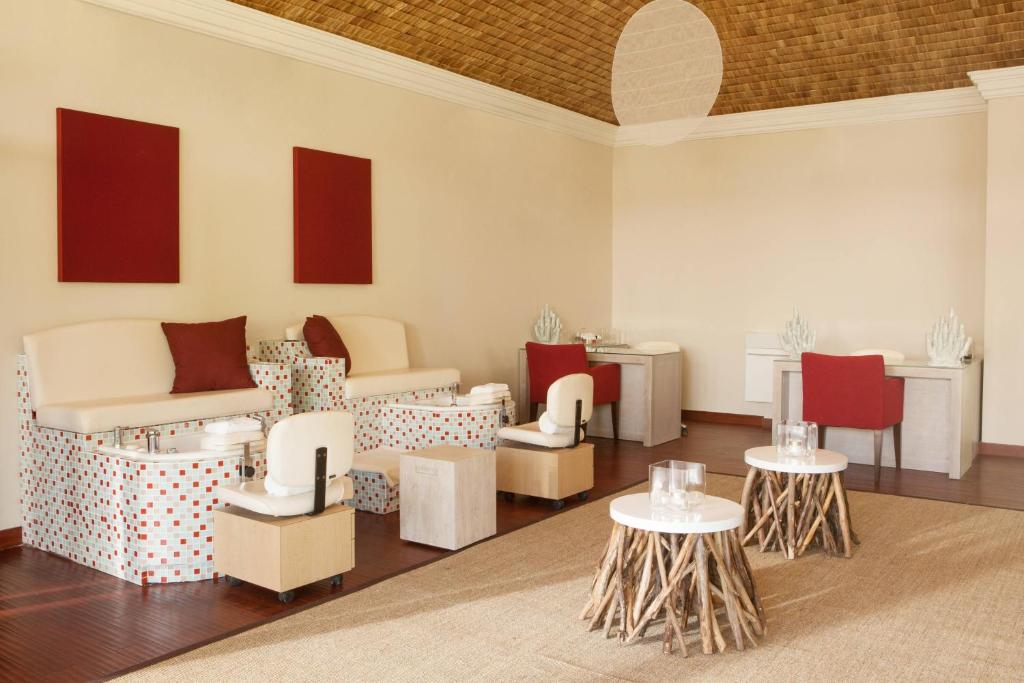 une chambre avec des chaises et des tables dans l'établissement The St Regis Bora Bora Resort, à Bora Bora