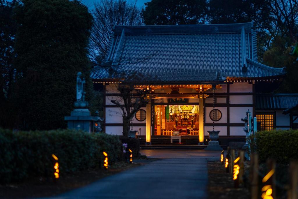 a building with lights in front of it at night at TEMPLESTAY ZENSŌ in Chiyodamachi
