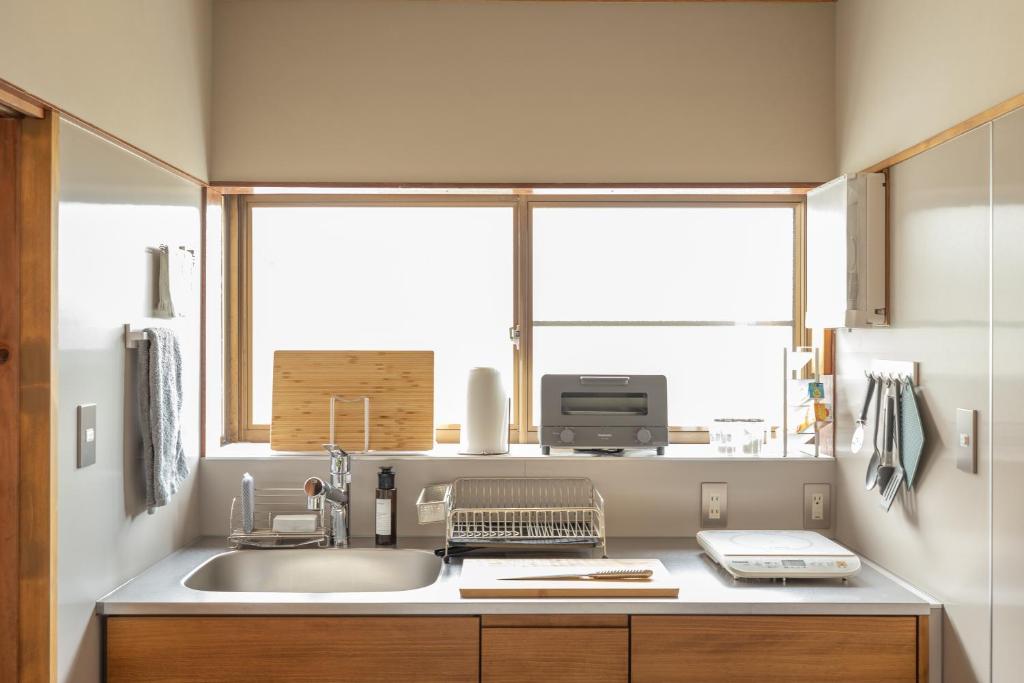 a kitchen with a sink and a window at TEMPLESTAY ZENSŌ in Chiyodamachi