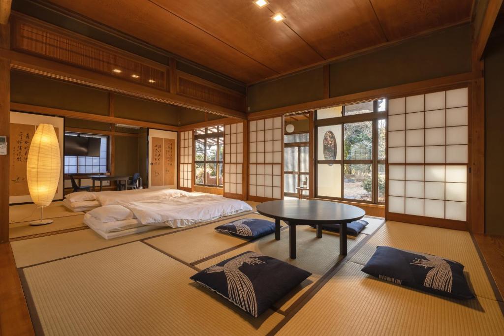 a bedroom with a bed and a table in it at TEMPLESTAY ZENSŌ in Chiyodamachi