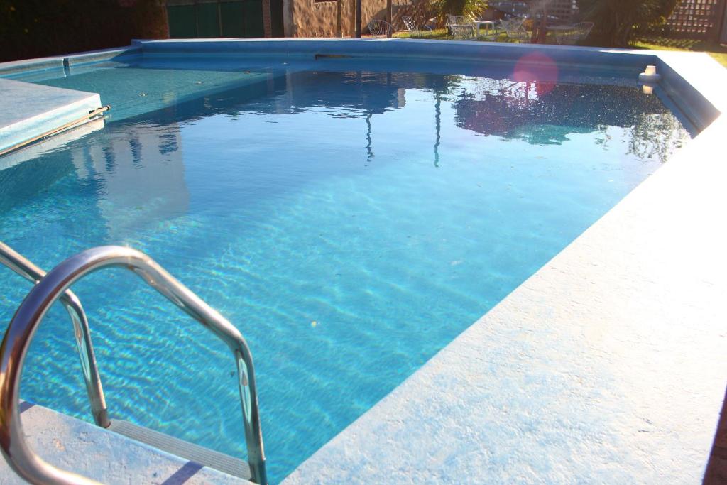 una piscina de agua azul y un pasamanos de metal en Hotel Roma en Capilla del Monte