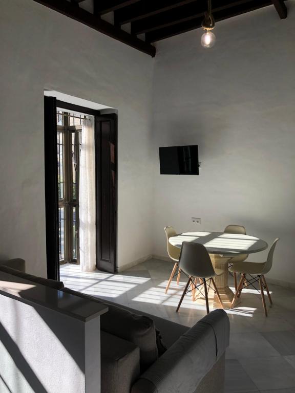 a living room with a table and chairs and a television at Apartamentos Makao Puerta del Olivillo in Jerez de la Frontera