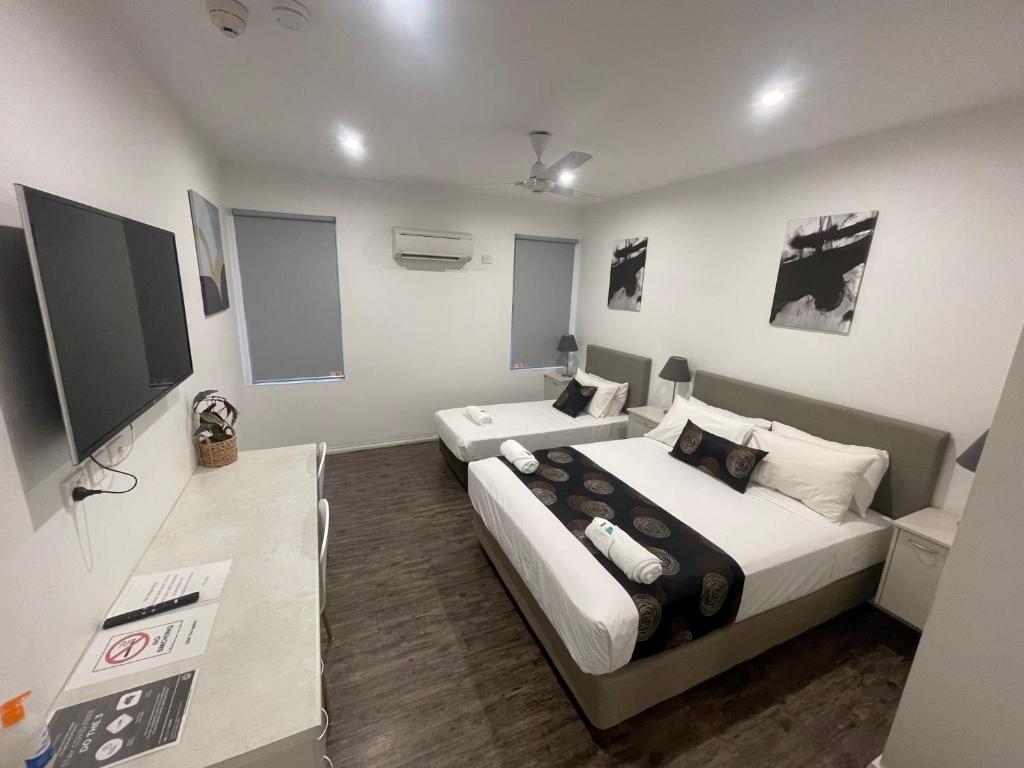 um quarto com 2 camas e uma televisão de ecrã plano em Winnellie Hotel Motel em Darwin