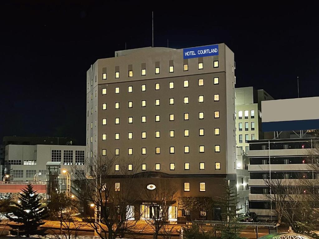 ein hohes Gebäude mit einem blauen Schild darüber in der Unterkunft Hotel Courtland in Nagano