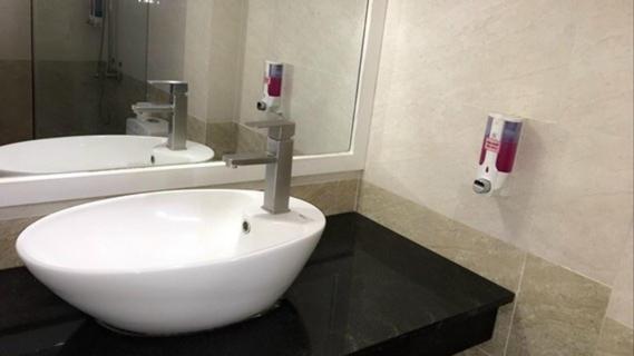 une salle de bains avec un lavabo blanc et un miroir dans l'établissement Muine Sports Resort, à Phan Thiết
