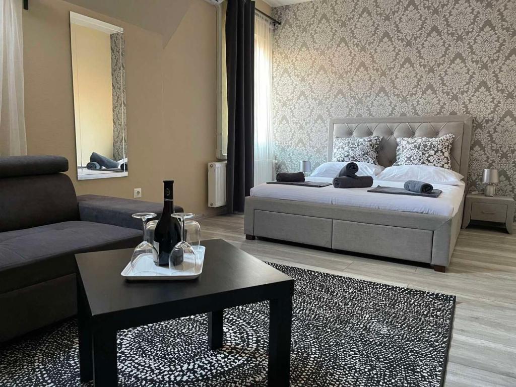 1 dormitorio con cama, sofá y mesa en Végvári Hotel Eger, en Eger