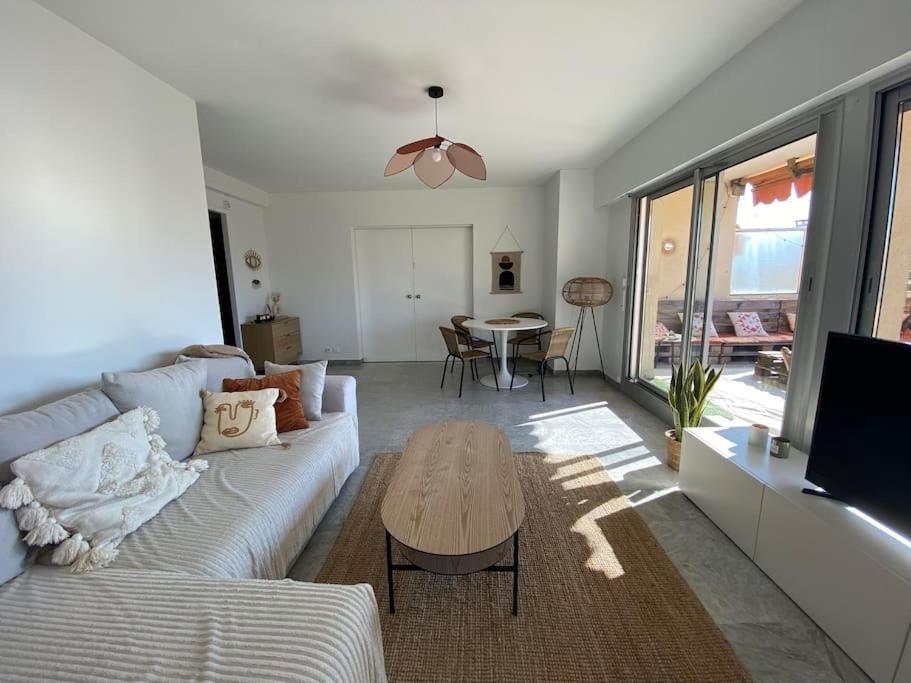 un salon avec un canapé et une table dans l'établissement Appartement avec terrasse, à Cannes