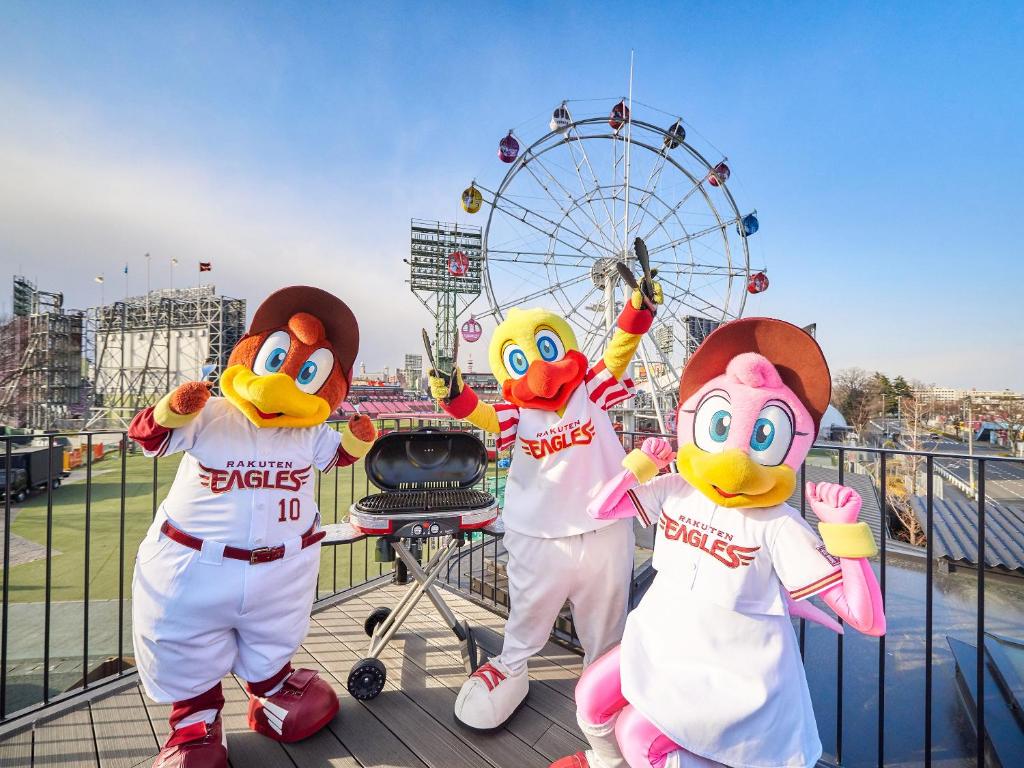 three marlins mascots in front of a ferris wheel at Rakuten STAY x EAGLES 201 with Roof balcony in Sendai